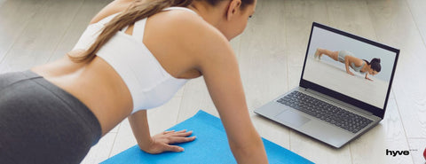 Žena cvičí doma dle online lekce.