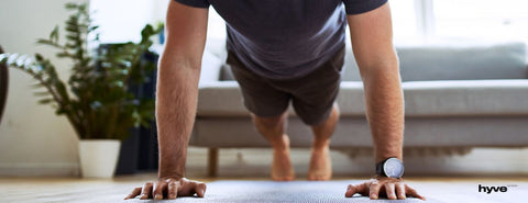 Muž cvičí doma klik.