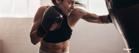 Žena boxuje do boxovacího pytle.