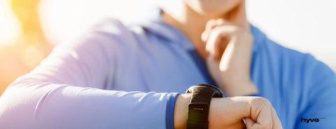 Žena si při sportu měří tep pomocí hodinek.