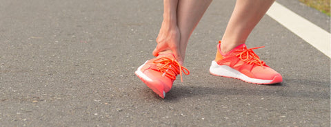 Běžec se drží za bolavý kotník.