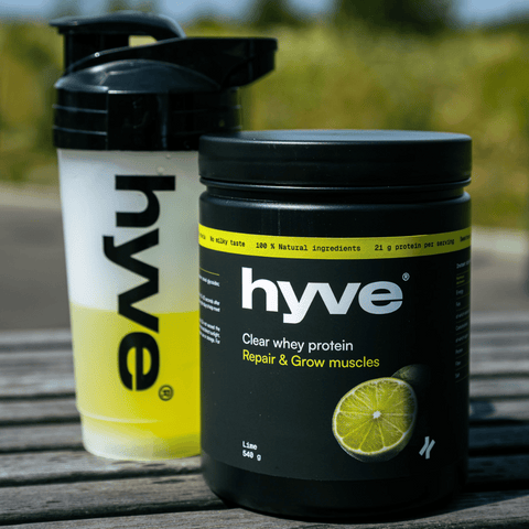 hyve clear whey limetka a rozmíchaný nápoj v shakeru na venkovním dřevěném stole