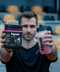 Sportovec na stadionu drží hyve Endurance Pro Blackberry & Lime a shaker s namíchaným nápojem