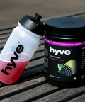 hyve Endurance Pro ostružina a limetka a bidon s růžovým nápojem na venkovním dřevěném stole