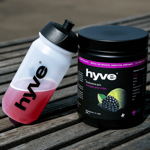 hyve Endurance Pro ostružina a limetka a bidon s růžovým nápojem na venkovním dřevěném stole