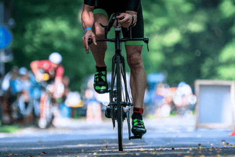 Závodník na kole při výjezdu z depa během triatlonového závodu.